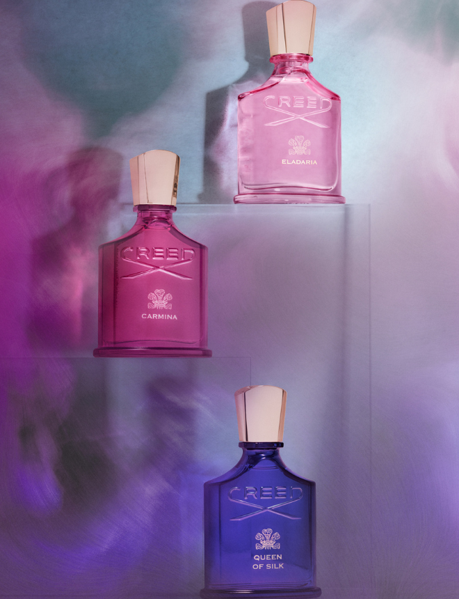 Drei farbige Creed-Parfümflakons in Pink, Magenta und Blau vor buntem Hintergrund, Artikelbild Nischendüfte