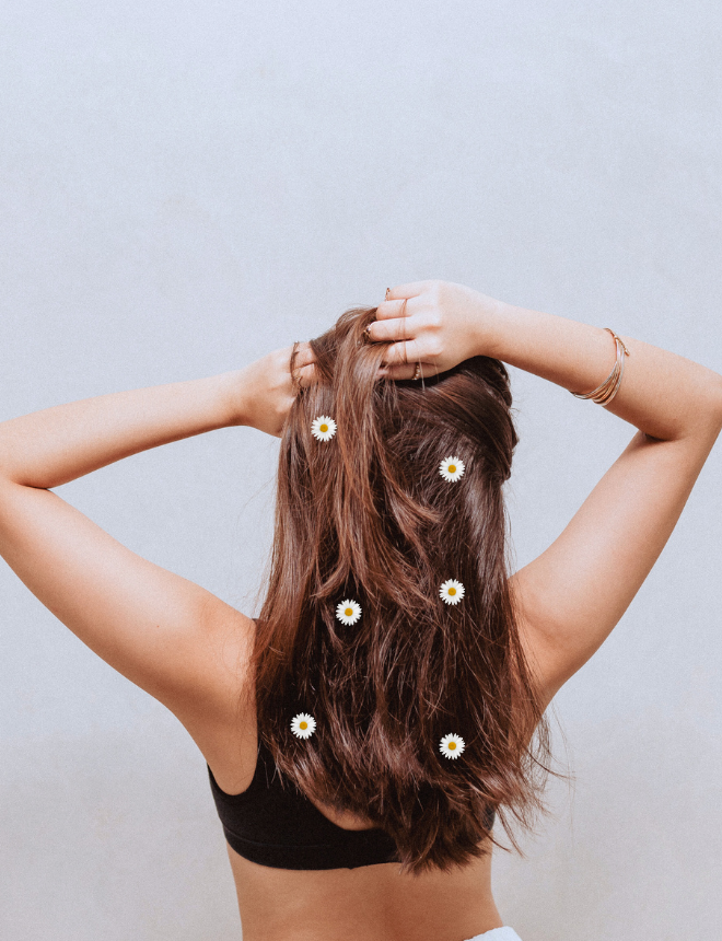 Frau von hinten mit langen braunen Haaren und weißen Blüten darin, Artikelbild Hair Mist