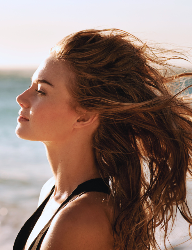Frau im Profil mit im Wind wehenden Haaren am Strand, Artikelbild Hair Mist