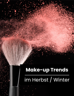 Banner Make-up Trends im Herbst/Winter, Pinsel mit aufwirbelndem rosa Puder vor schwarzem Hintergrund