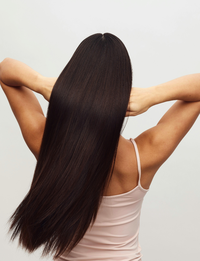Frau von hinten mit langen, glänzenden, glatten Haaren – Ergebnis der Sensai Haarpflege