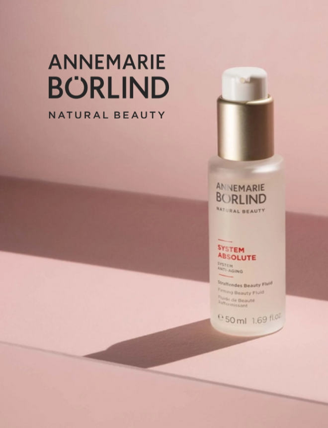 Annemarie Börlind Natural Beauty Logo mit System Absolute Straffendem Beauty Fluid Flakon vor rosa Hintergrund
