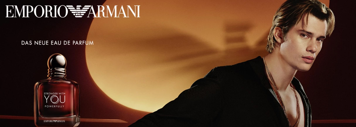 Emporio Armani Stronger With You Powerfully Eau de Parfum Flakon neben Porträt eines Mannes vor orangefarbenem Sonnenuntergrund