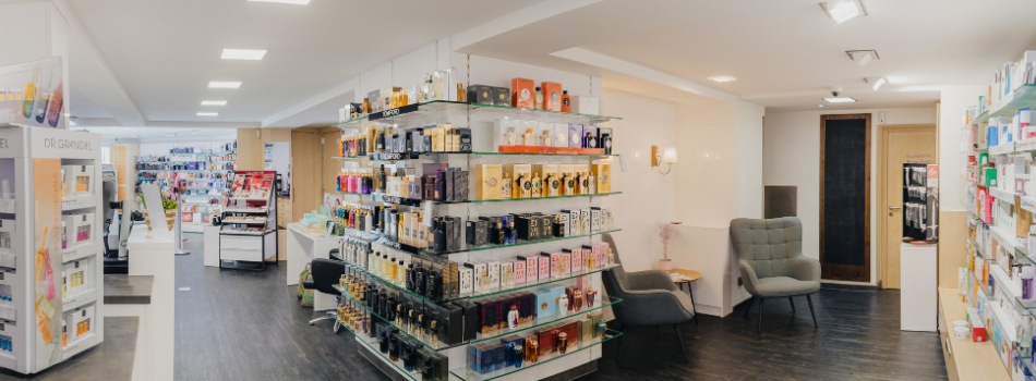 Verkaufsraum der Parfümerie mit Glasregalen voller Parfums und gemütlicher Sitzecke