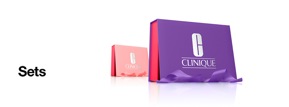 Zwei Geschenkkartons von Clinique, einer in Pink und einer in Lila, daneben der Schriftzug 'Sets'.