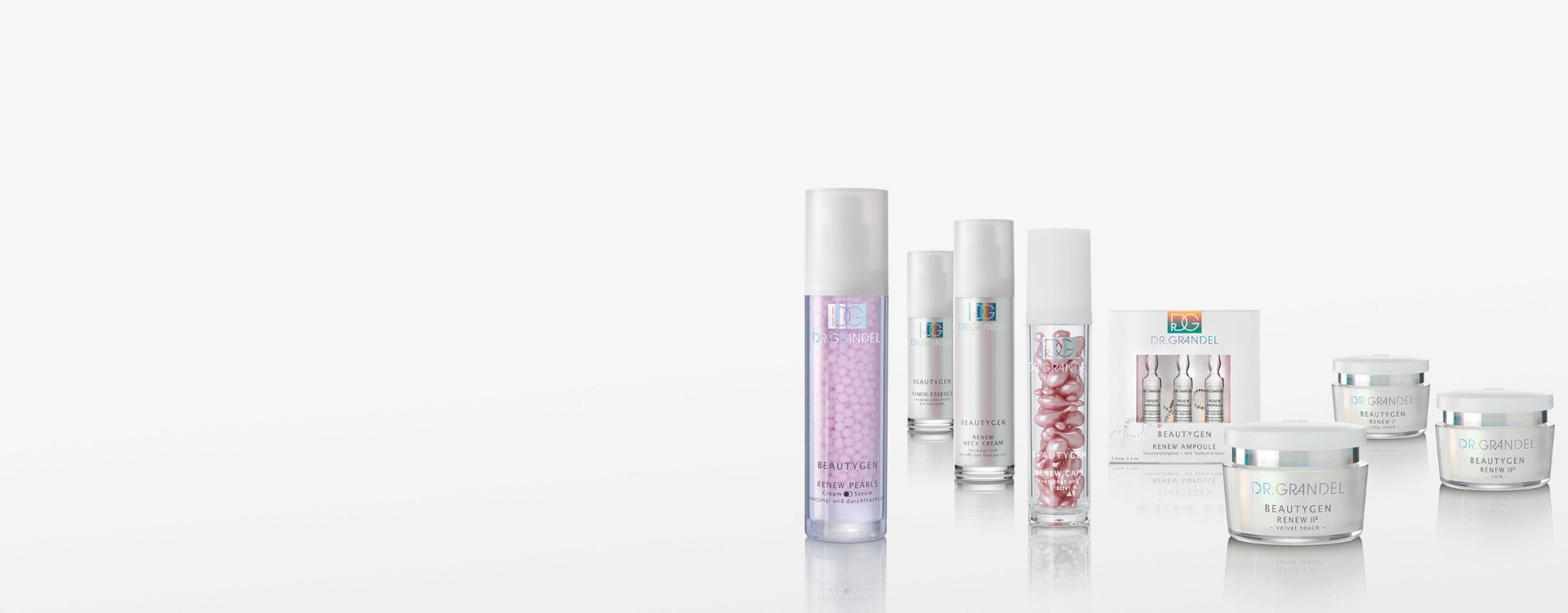 Dr. Grandel Beautygen Pflegeserie mit eleganten weißen und silbernen Verpackungen, darunter Cremes, Seren, Kapseln und Ampullen, auf hellem Hintergrund arrangiert.