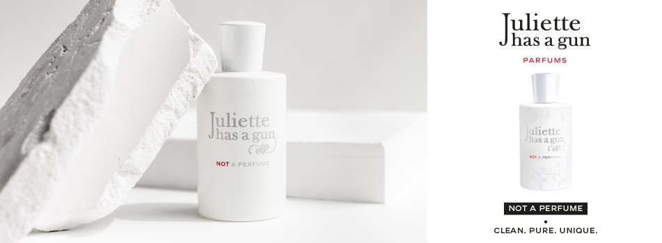 Werbebild für das Parfüm ‚Not a Perfume‘ von Juliette has a gun. Links steht ein weißer Flakon mit schlichter Aufschrift vor einem weißen Hintergrund mit einem kantigen Gesteinsbrocken. Rechts daneben der Markenname ‚Juliette has a gun‘ und darunter erneut der Flakon. Text: ‚Not a Perfume – Clean. Pure. Unique.‘