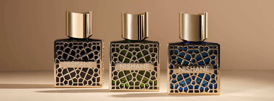 Drei luxuriöse Parfumflakons der Marke Nishane stehen nebeneinander auf beigem Untergrund. Jeder Flakon hat eine glänzende goldene Kappe und eine kunstvolle goldene Gitterstruktur über dem Glas in Schwarz, Grün und Blau. Auf jedem Flakon steht der Markenname 'NISHANE'.