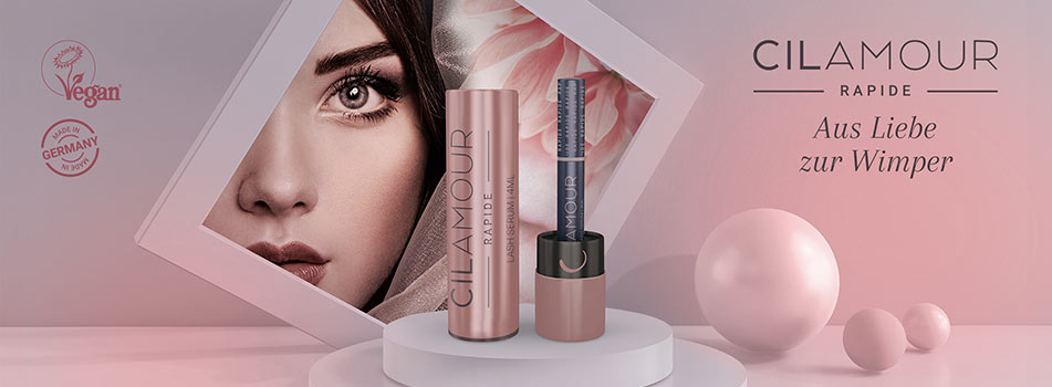 Werbemotiv für Cilamour Rapide Wimpernserum in Rosa- und Beigetönen. Links ein Close-up eines Frauenauges mit langen Wimpern in einem geometrischen Rahmen. In der Mitte zwei Cilamour-Produkte, rechts der Schriftzug: 'CILAMOUR RAPIDE – Aus Liebe zur Wimper'. Oben links Logos mit 'Vegan' und 'Made in Germany'.